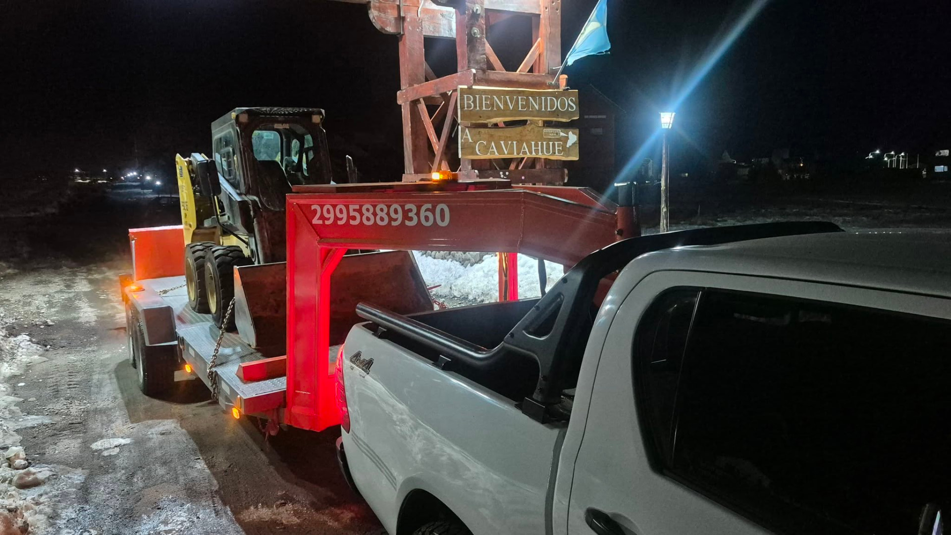 Traslado nocturno de una minicargadora sobre trailer en el ingreso a Caviahue